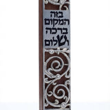 Dark mahogany wood mezuzah with pewter swirling design and blessing inscription, on a white studio background with soft reflection.